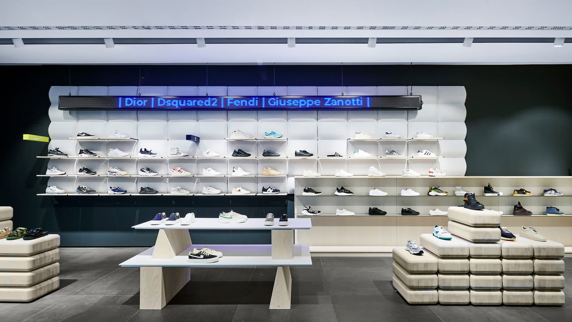 Hochwertiges Wand-System für Schuhpräsentation in Modegeschäft, inklusive Marken wie Dior, Fendi, Giuseppe Zanotti. Modernes Design für ansprechende Verkaufsflächen.