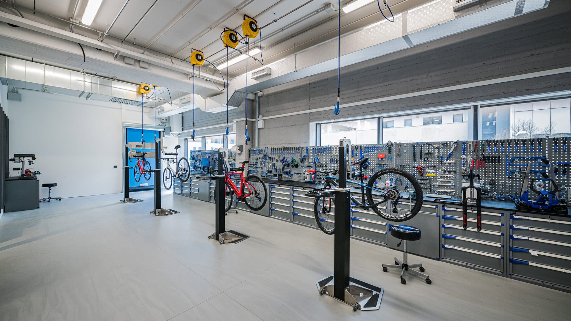 Moderne Fahrradwerkstatt mit Fahrradmontage und Reparaturstationen, Werkzeuge und Fahrradteile in einer gut ausgestatteten Umgebung.