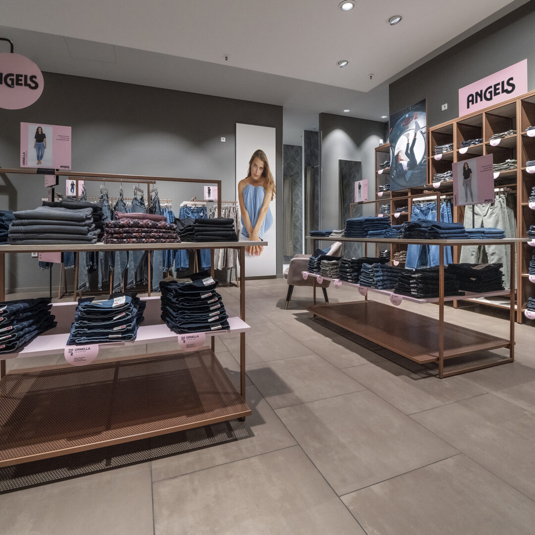 Modernes Angels Shop in Shop Jeansgeschäft mit gut sortierten Regalen und Displays, präsentiert verschiedene Denim-Modelle und Marken in einem stilvollen Laden.
