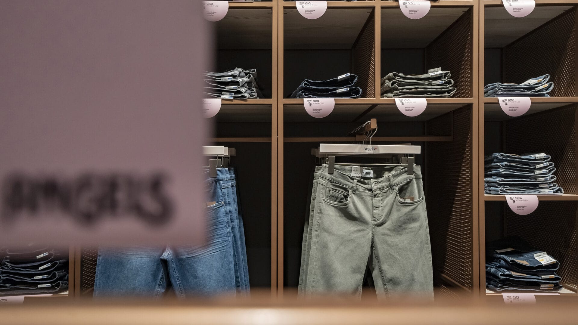 Hochwertige Jeans in verschiedenen Stilen und Farben im von KRAISS gebauten Modegeschäft.