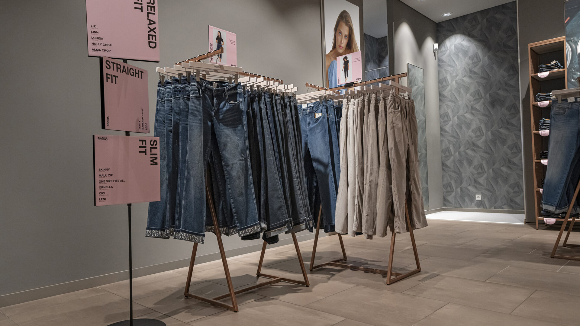 Hochwertige Jeans und Hosen in verschiedenen Passformen und Farben, präsentiert auf Kleiderständern in einem modernen Modegeschäft. Perfekt für stilbewusste Kunden, die Komfort und Trend suchen.