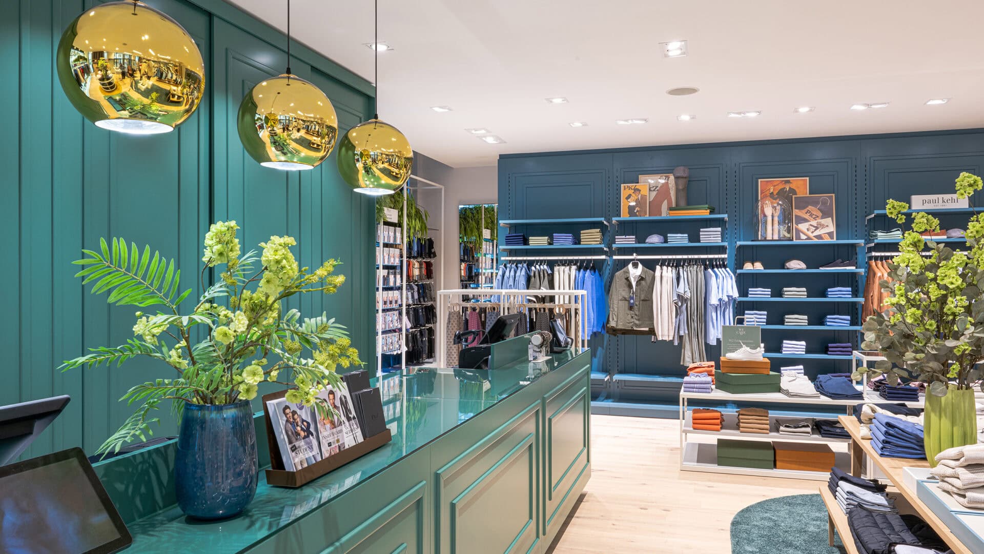 Innenansicht der PKZ Modeboutique mit stilvoller Einrichtung, grünen Wänden, modernen Dekorationen und gut sortierten Regalen.