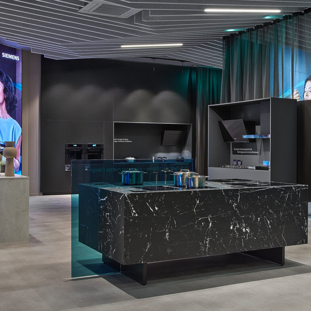 Moderne KRAISS Ausstellung mit Siemens Haushaltsgeräten und innovativen Küchendesigns in einem stilvollen Showroom.