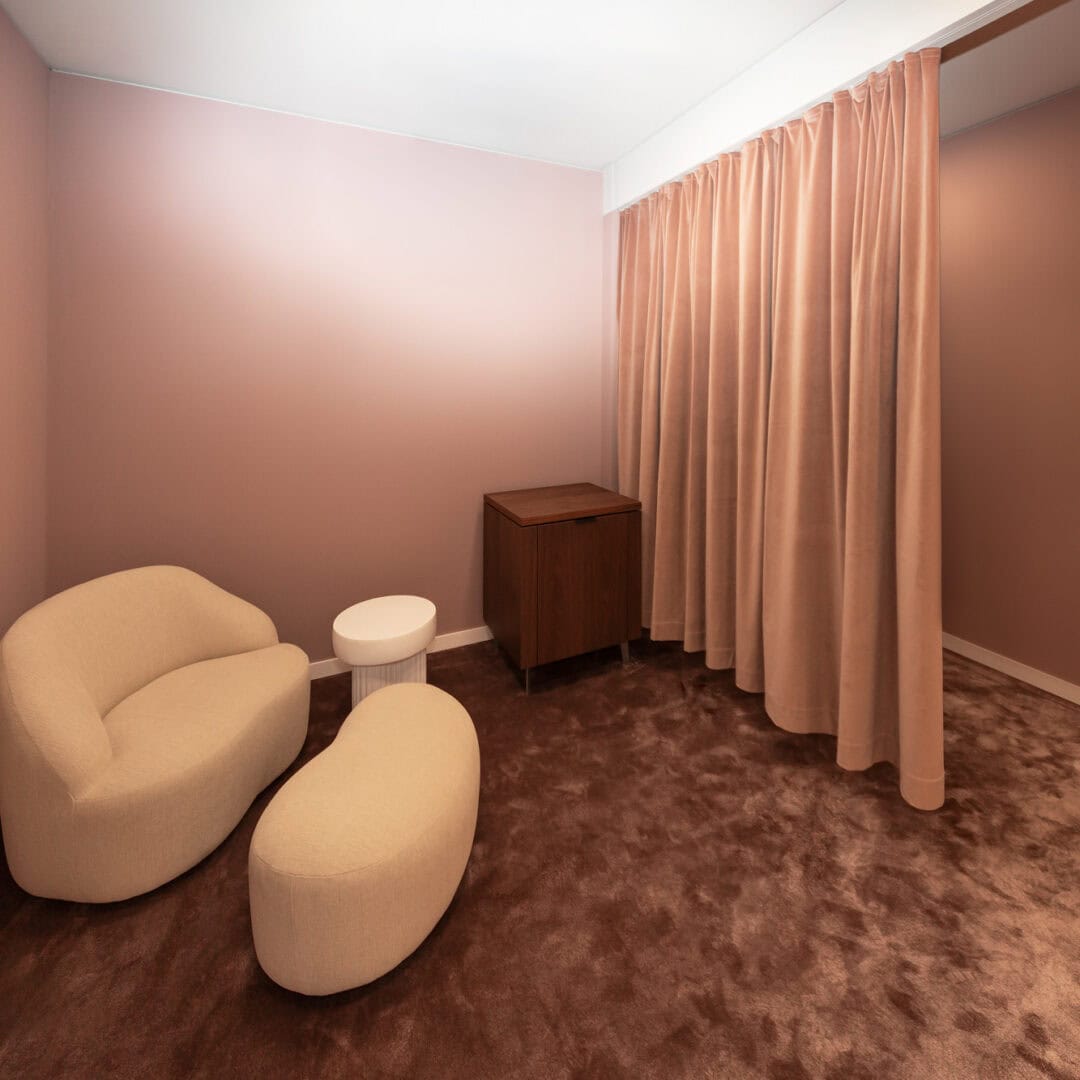 Gemütlicher VIP-Shopping Raum mit bequemen Sitzmöbeln, Vorhängen und Holzmöbeln, ideal für Entspannung oder private Gespräche.