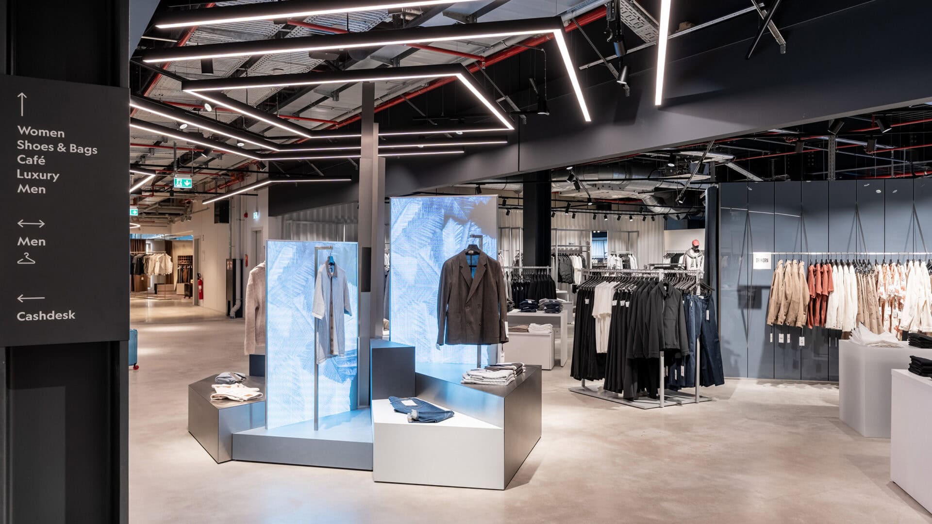 Moderne Modeboutique mit trendiger Beleuchtung, Kleidung und Accessoires im KRAISS Store, ansprechend gestaltet für ein elegantes Einkaufserlebnis.