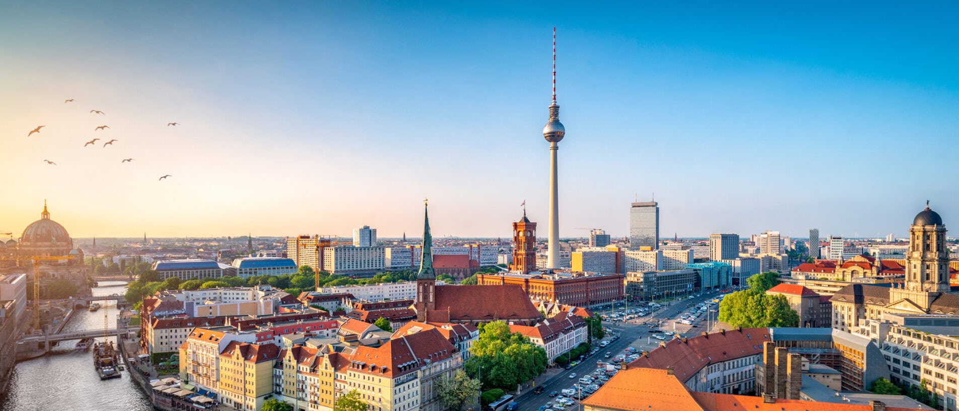 Panoramablick auf die Berliner Skyline mit Fernsehturm, historischen Gebäuden und moderner Architektur bei Sonnenuntergang, ideal für Stadt- und Reiseblogs.